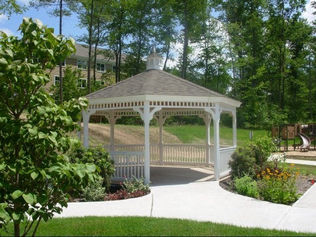 a white gazebo in the middle of a park