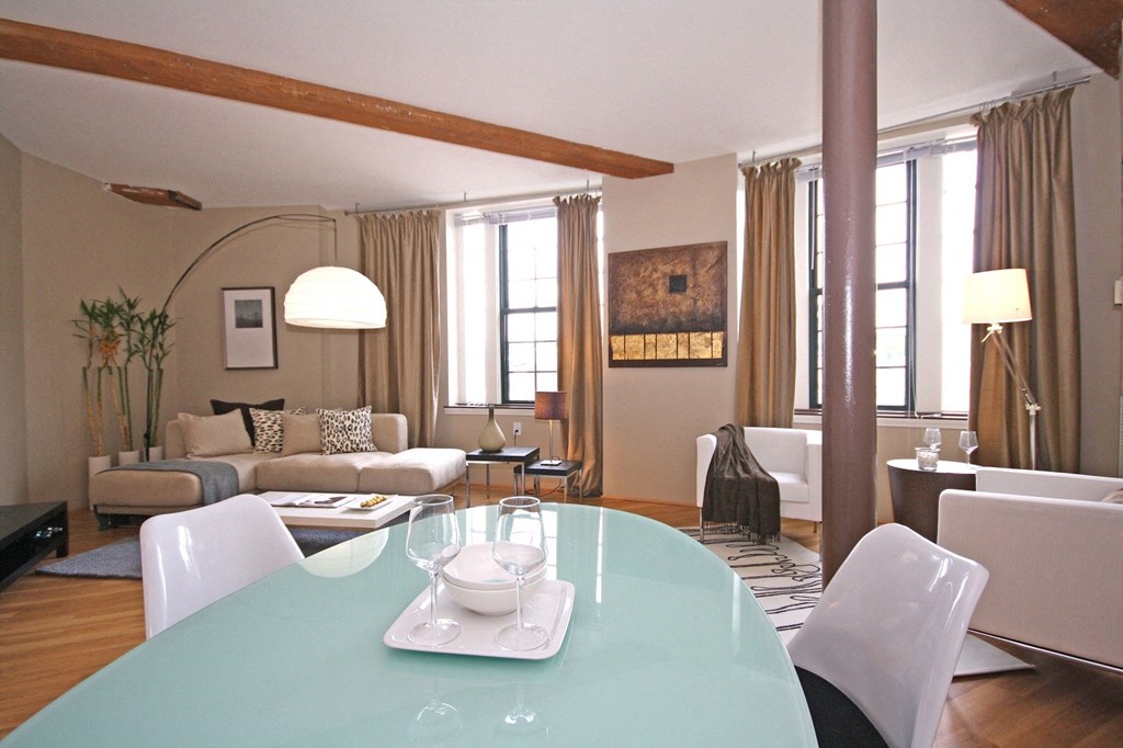 a living room and dining room with a table and chairs