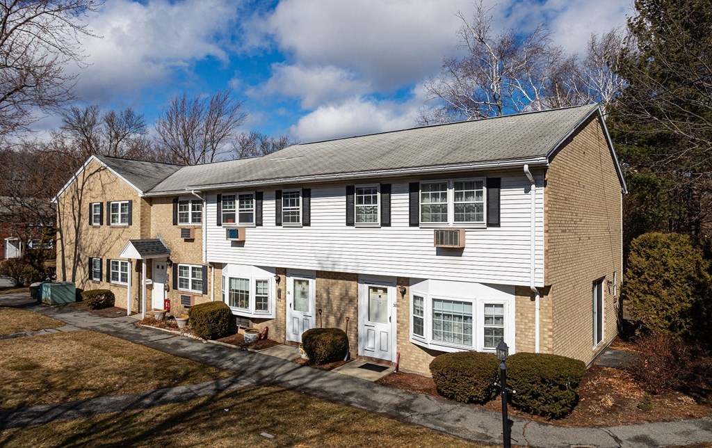 A two-story house with a grey roof and white siding.