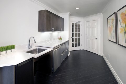 a modern kitchen with stainless steel appliances and white counter tops