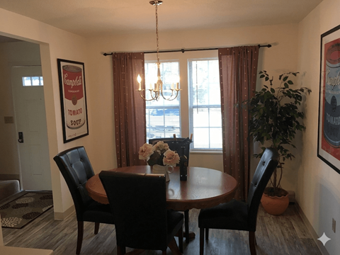 A dining room with a table and chairs.
