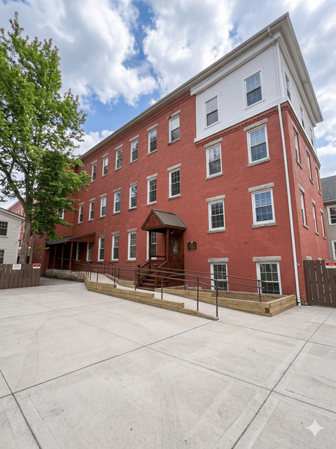 A red brick building with a white trim and a tree in front.