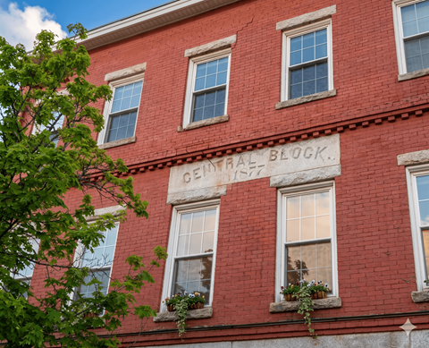 A red brick building with windows and a sign that says "CENTRAL BLOCK".