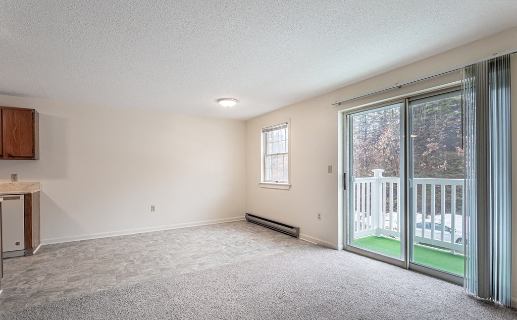 A room with a sliding glass door leading to a balcony.
