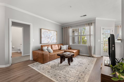 A living room with a brown leather couch and a coffee table.