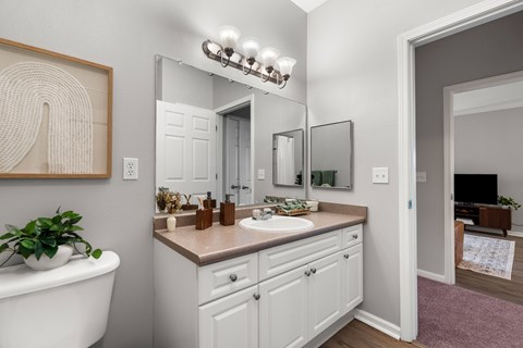 A bathroom with a white tub, sink, and vanity.