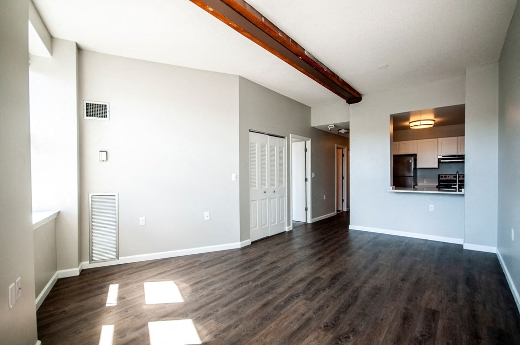 an empty living room with white walls and wood floors