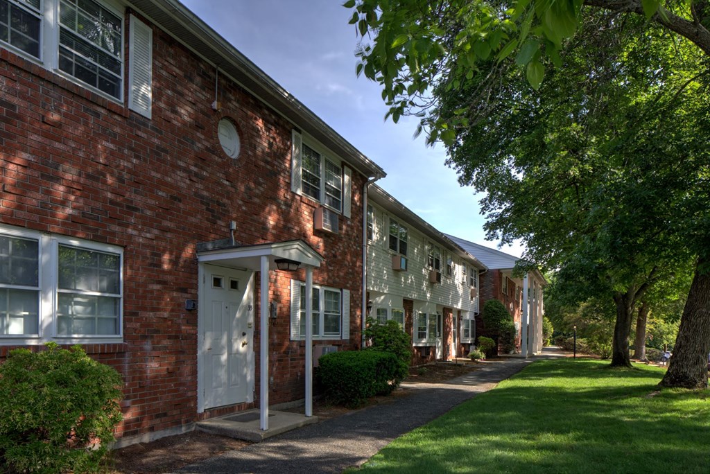 A red brick building with a white door and windows.