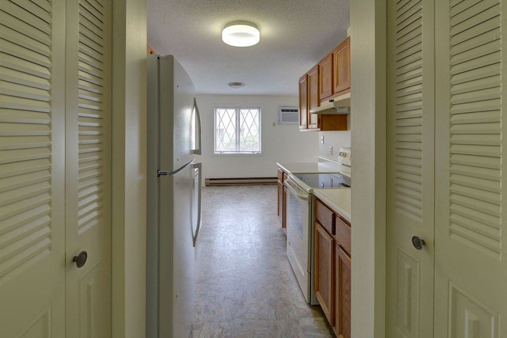 A kitchen with white cabinets and a refrigerator.