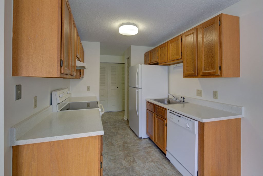 A kitchen with wooden cabinets and white appliances.