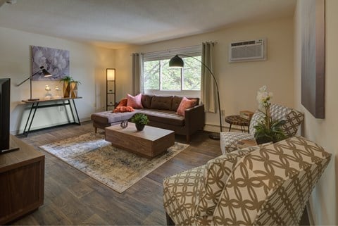 A living room with a brown couch and a patterned chair.
