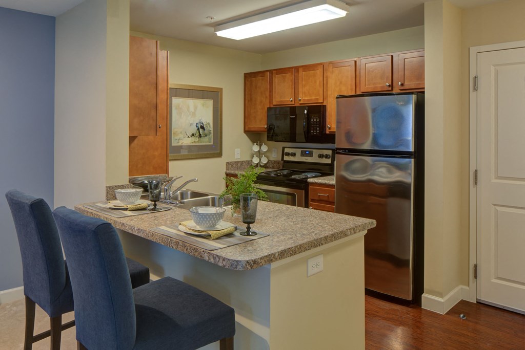 a kitchen with a granite counter top and a stainless steel refrigerator