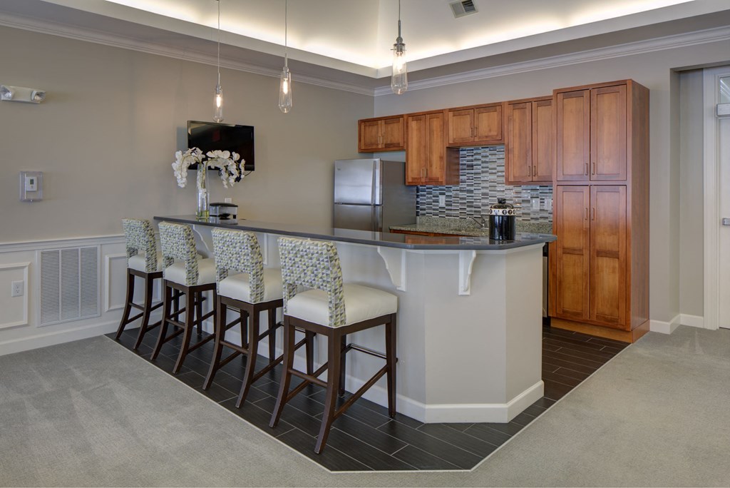 a kitchen with a bar with four stools