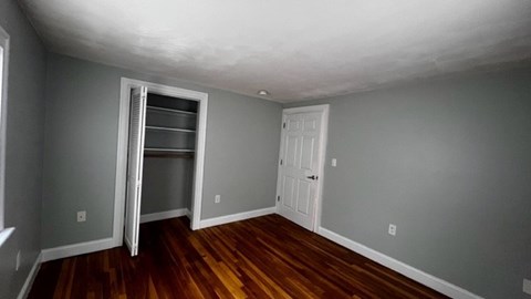 A room with a wooden floor and a white door.
