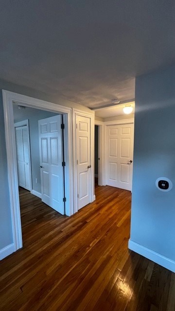 A hallway with two doors and a wood floor.