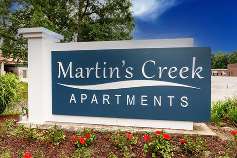 A sign for Martin's Creek Apartments is shown in front of a building.