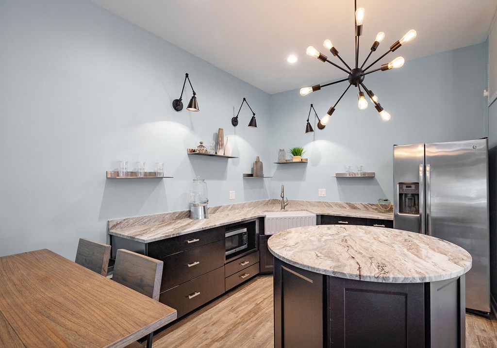 A modern kitchen with a central island and a wooden table.