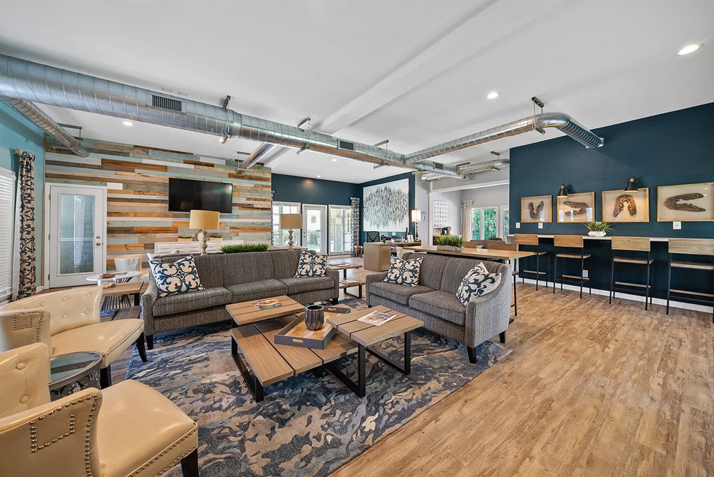 A modern living room with a wooden floor and a large sectional sofa.