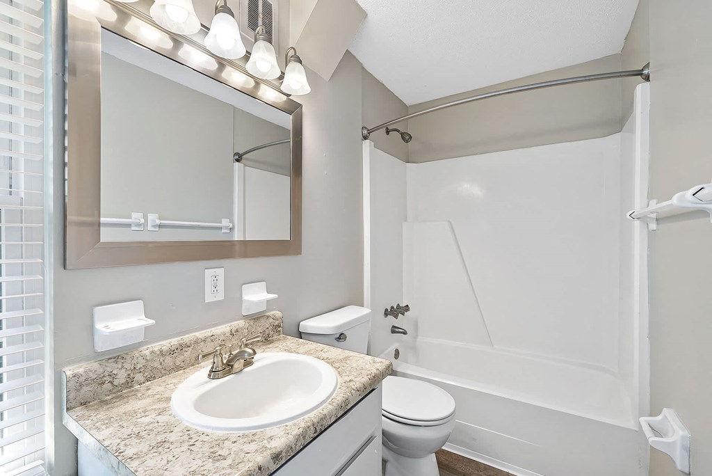 A bathroom with a sink, toilet, and shower.