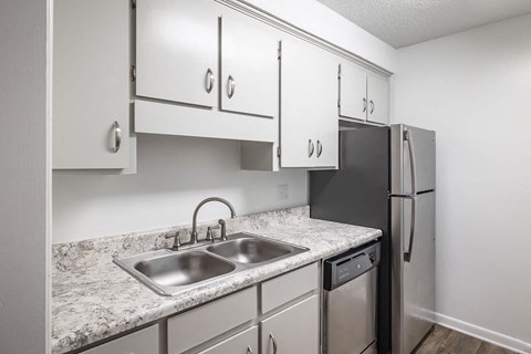 A kitchen with a sink and a refrigerator.