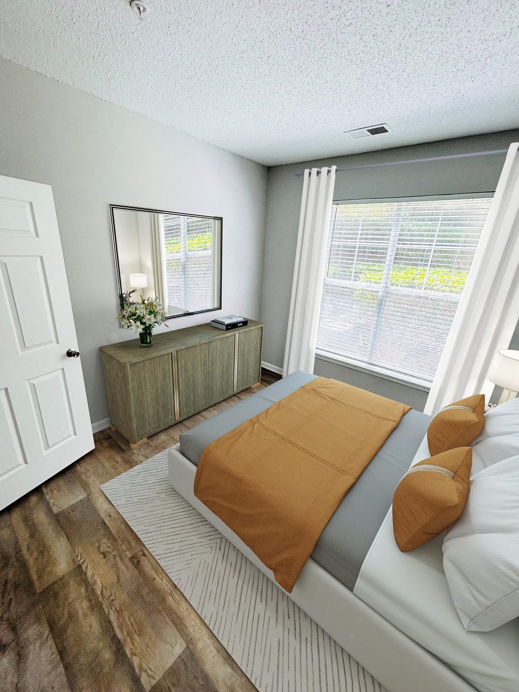 A bedroom with a bed, dresser, and mirror.