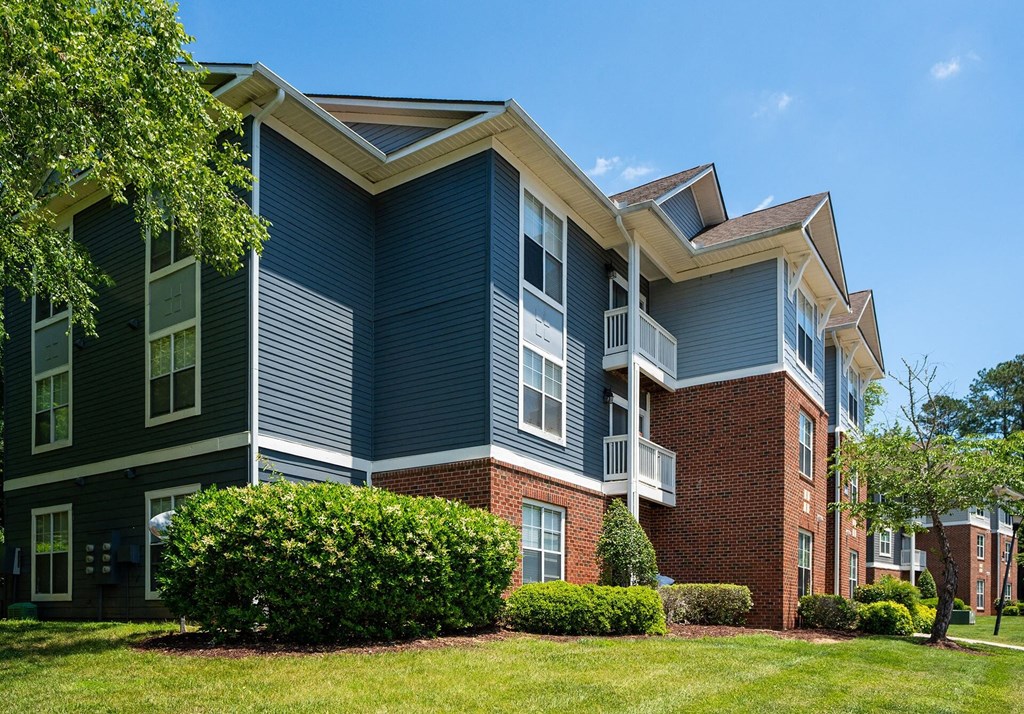 A modern apartment building with a mix of brick and siding exterior.