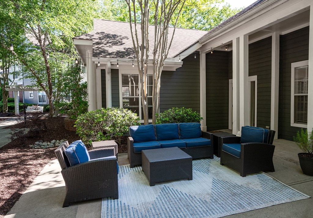 A patio with a couch, chairs, and a table.