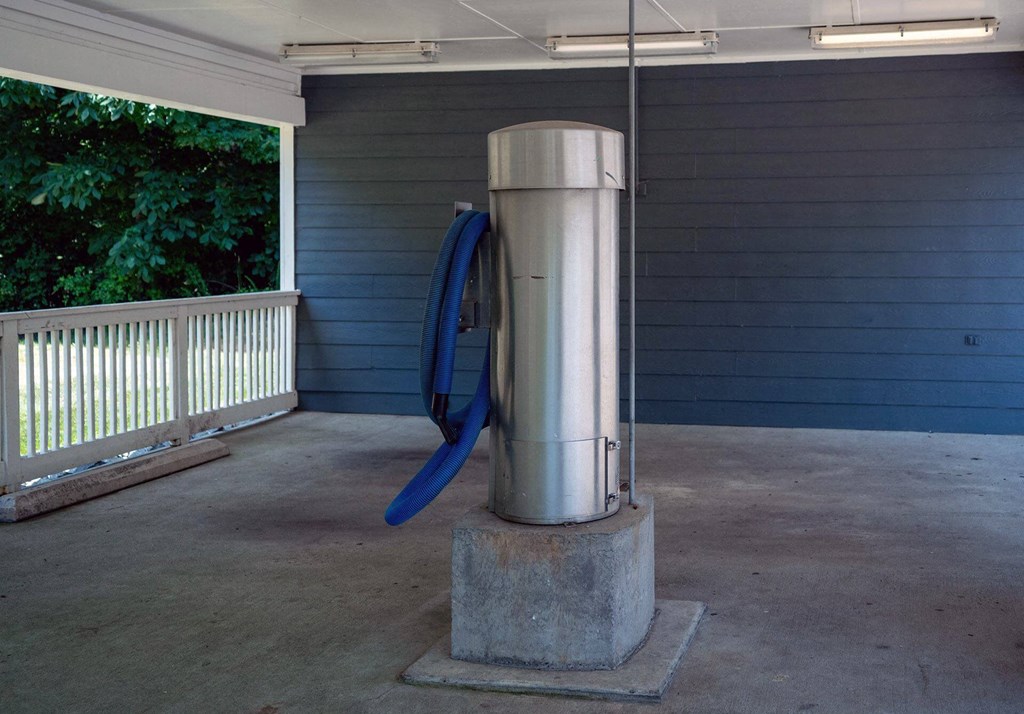 A large blue object is attached to a silver pole in a room with a concrete floor.