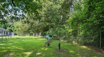 A playground with a slide and a swing set in a green park.