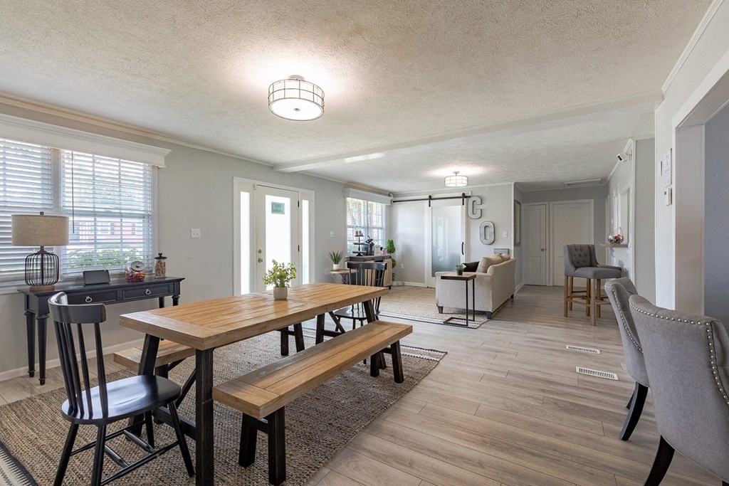A dining room with a wooden table and chairs.