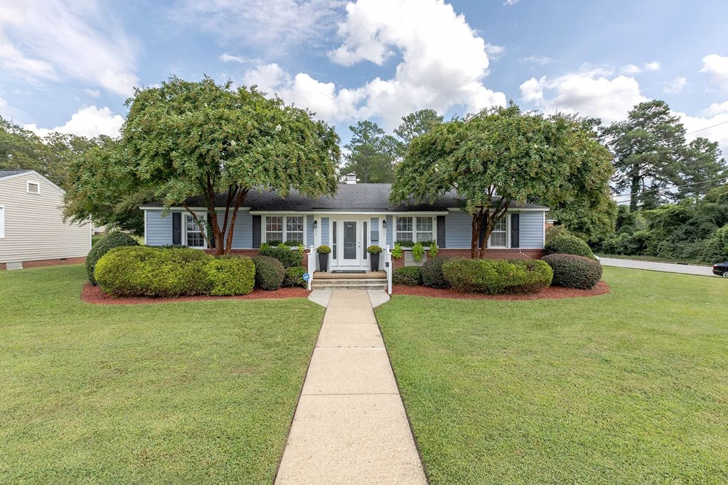 A house with a white front door and two windows.