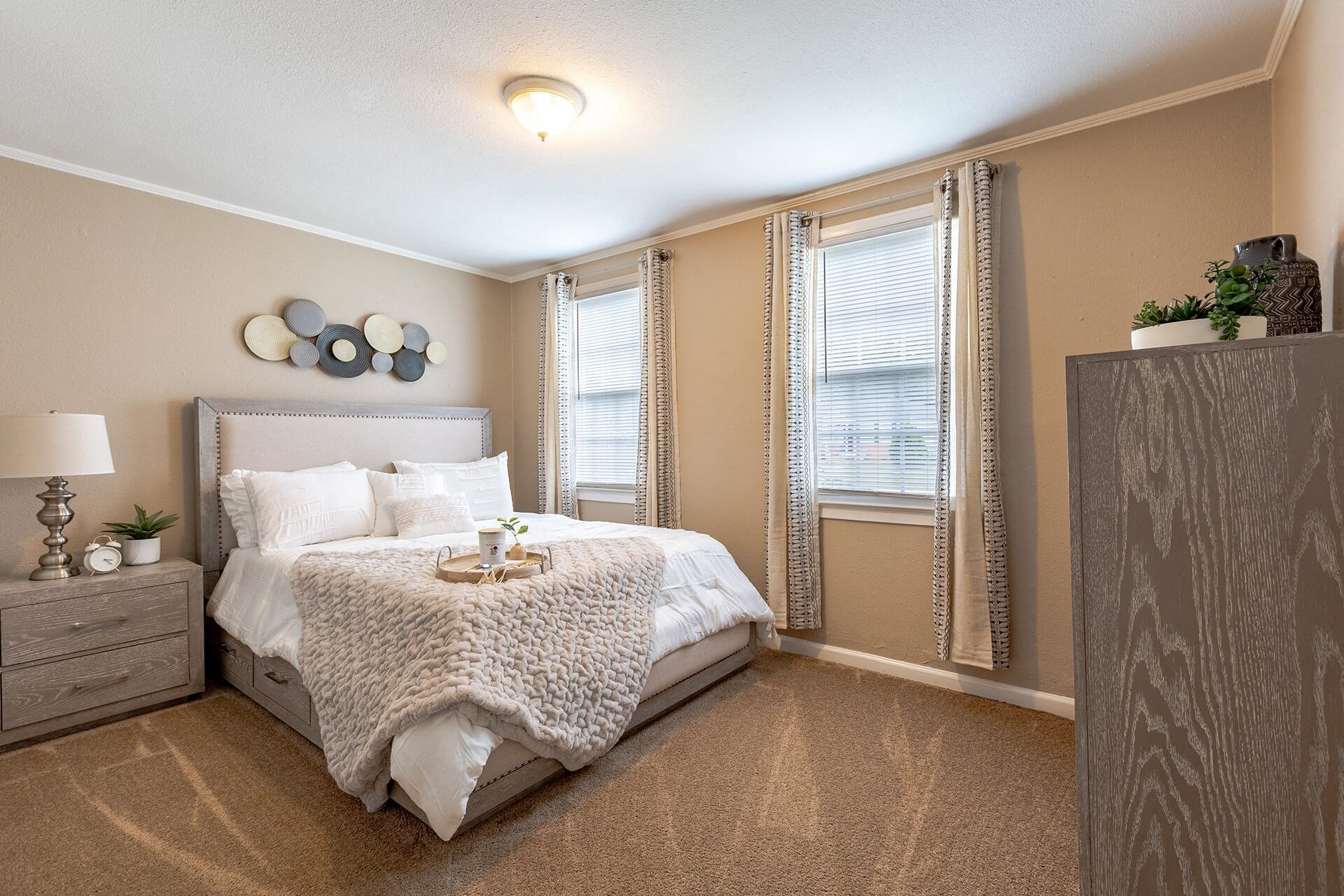 A bedroom with a large bed and a nightstand with a lamp.