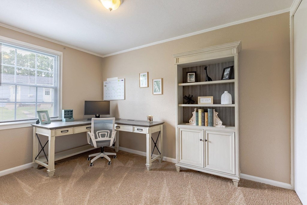 A room with a desk, chair, and bookshelf.