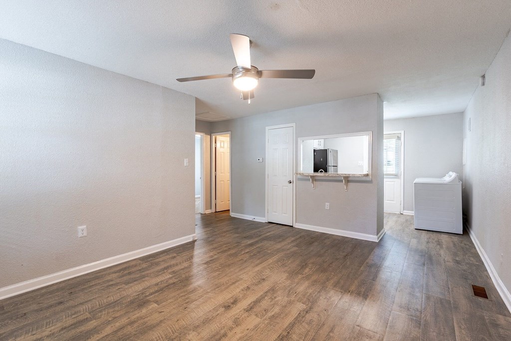 A spacious room with a ceiling fan and light fixture.
