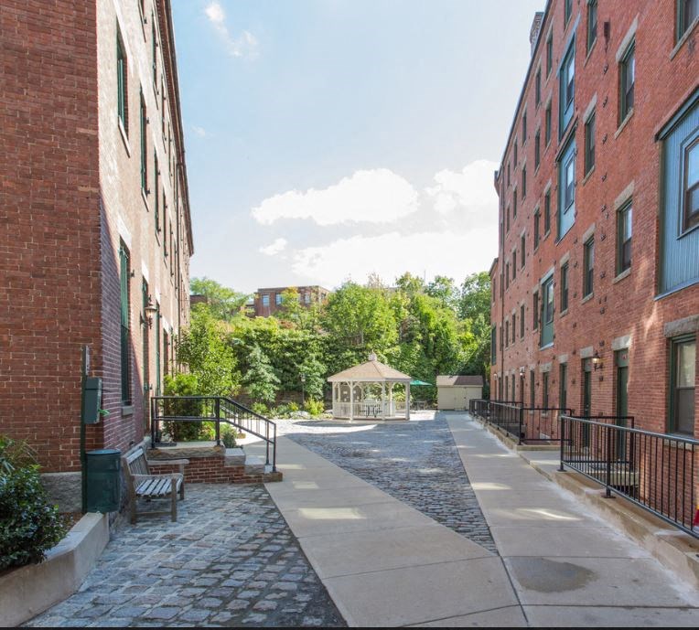 a street with brick buildings and a gazebo in the middle