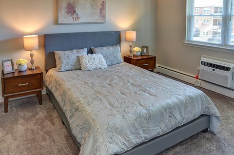 A bedroom with a large bed and a window.