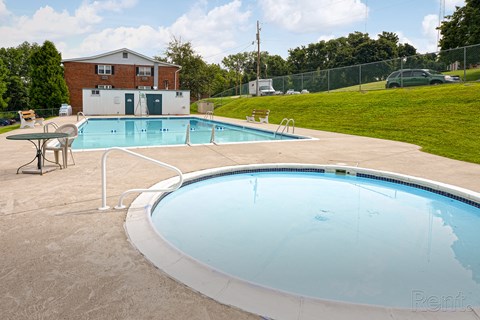 A large outdoor swimming pool and Hot Tub with furniture to relax