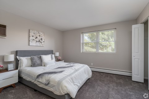 A bedroom with a large bed and a window.