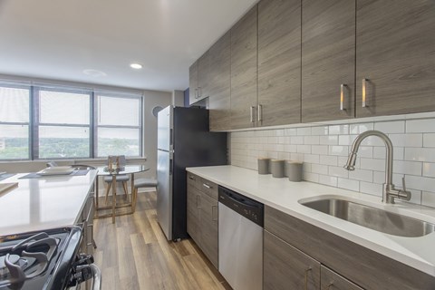 A modern kitchen with a black refrigerator and stove top oven.
