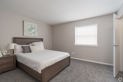A bedroom with a large bed and a window.