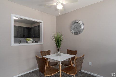 A dining room with a white table and chairs.