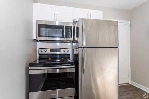 A kitchen with a stainless steel refrigerator, oven, and microwave.