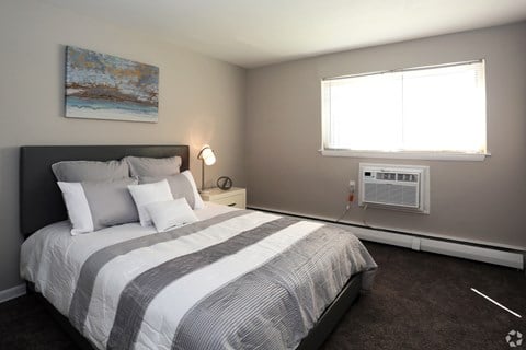 A bedroom with a large bed and a painting on the wall.