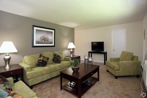 A living room with a couch, chair, and television.