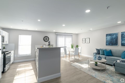 A modern kitchen with a large island and a dining area with a sofa.