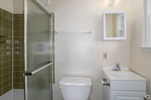 A white toilet sits next to a white sink in a bathroom.