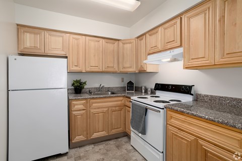 A kitchen with wooden cabinets and a white fridge.