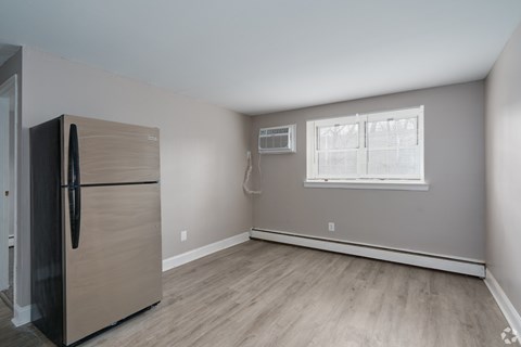 A kitchen with a refrigerator and a window.