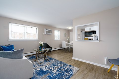 A living room with a blue rug and a grey armchair.