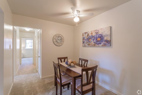 A dining room with a wooden table and chairs.